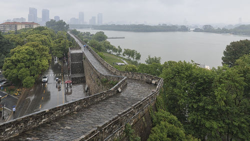 High angle view of river amidst city against sky