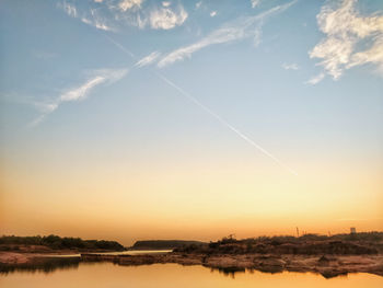 Scenic view of vapor trails in sky during sunset