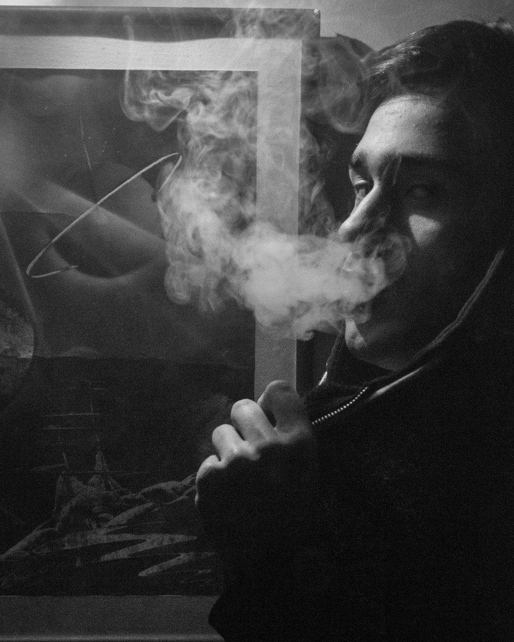 PORTRAIT OF MAN SMOKING CIGARETTE ON FLOOR