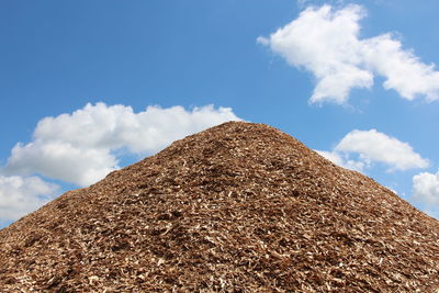 Low angle view of rocks against blue sky