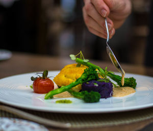 Cropped image of hand holding spoon over food