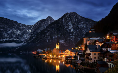 View of town illuminated at waterfront during dusk