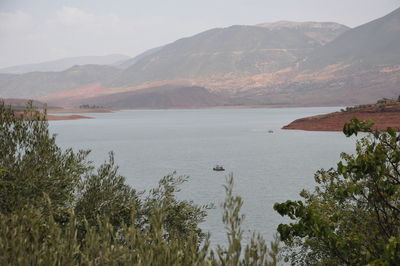 Scenic view of sea and mountains against sky