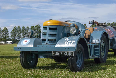 Vintage car on field against sky