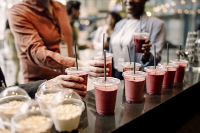 Business delegates picking up juice glasses from bar counter at convention center