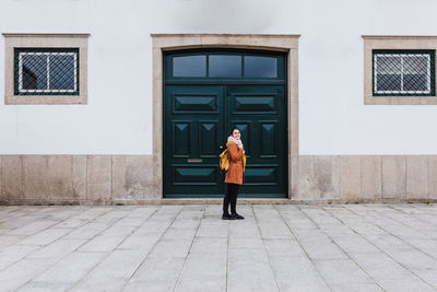 Full length of woman standing against building