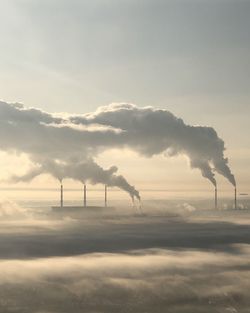 Smoke emitting from chimney against sky