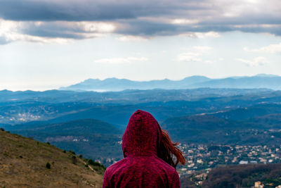 Rear view of woman looking at mountains against sky