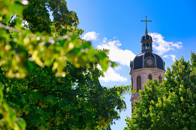 Low angle view of trees and building against sky