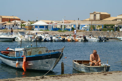 Boats moored at beach against clear sky