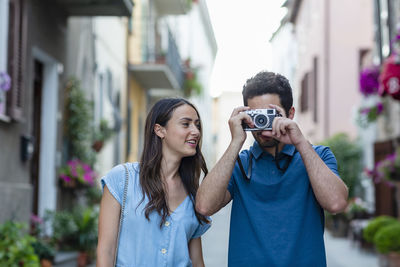 Portrait of young couple holding camera