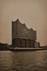 Building by sea against sky during sunset