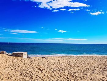 Scenic view of beach against blue sky