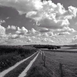 Dirt road passing through field