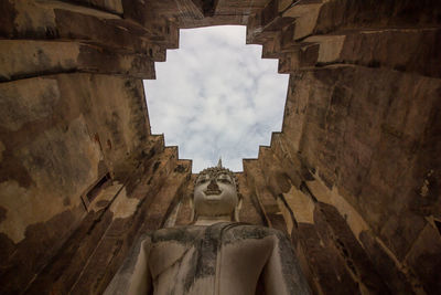 Directly below shot of buddha statue in abandoned building