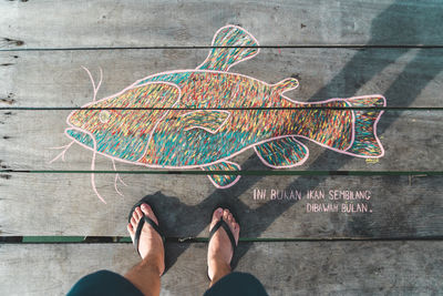 Low section of man standing on multi colored text