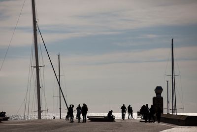 People on sailboat by sea against sky