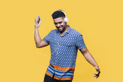 Young man wearing mask against yellow background