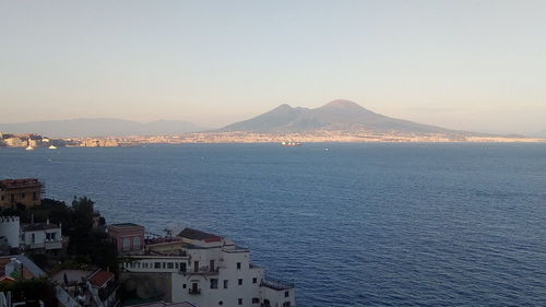 Aerial view of town by sea against clear sky