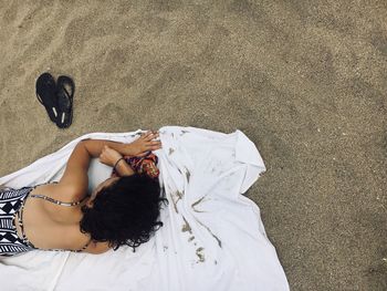 High angle view of woman lying down on sand