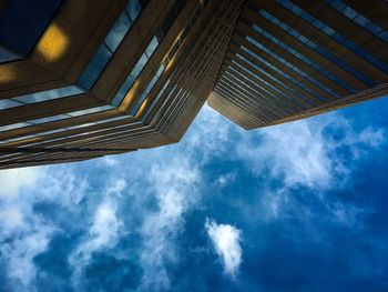 Low angle view of modern building against cloudy sky
