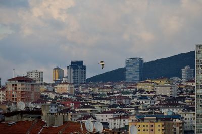 Buildings in city against cloudy sky