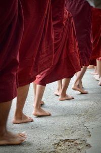 Low section of monks walking on footpath