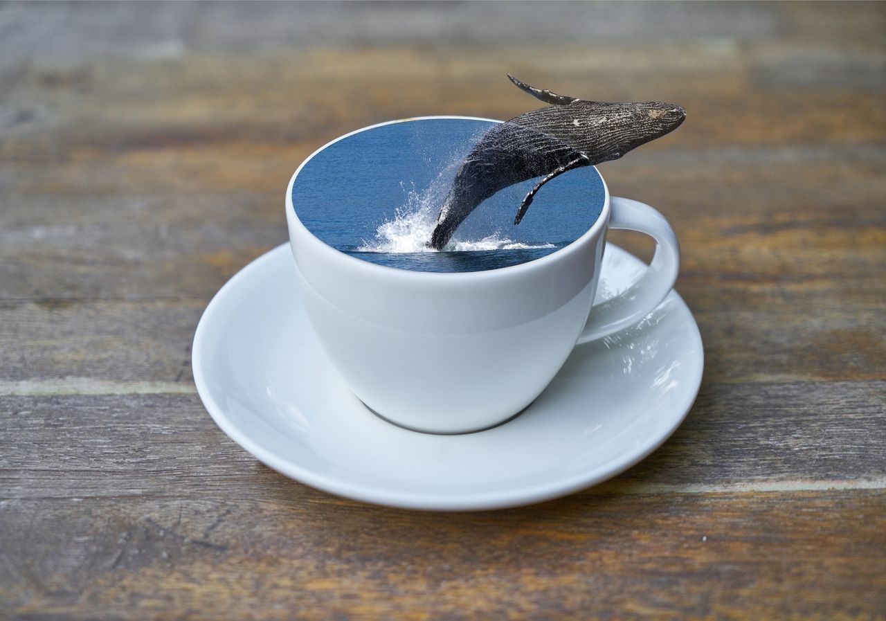 CLOSE-UP OF COFFEE CUP AND SPOON ON TABLE