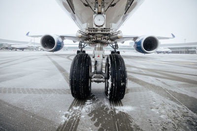 Front view of airplane landing gear. winter frosty day at airport during snowfall.