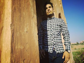 Young man standing against wall