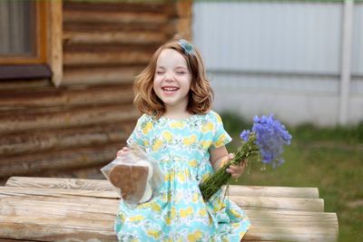 Cute little girl in autumn park holding bunch of yellow leaves