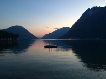 Idyllic shot of floating platform in lake lugano by mountains against sky