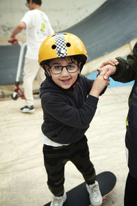Portrait of boy learning how to skateboard in indoor skatepark