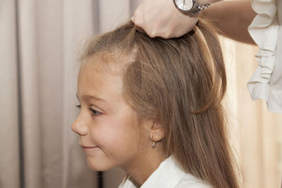 Midsection of mother tying daughter hair