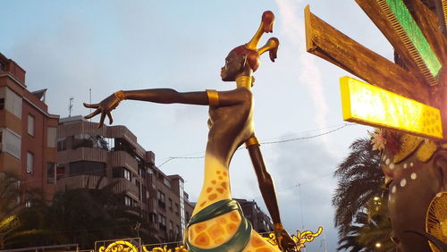 Low angle view of statue against building against sky