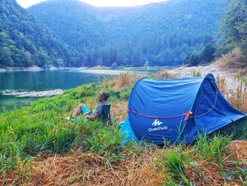 Rear view of tent on mountain by lake