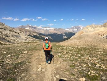 Rear view of man on mountain road against sky