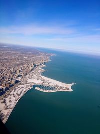 Aerial view of sea and cityscape against sky