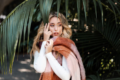 Fashionably dressed blonde-haired young woman in a park on an autumn day