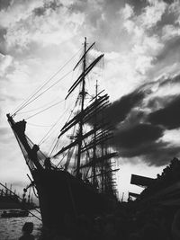 Low angle view of sailboats moored in sea against sky