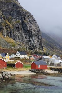 Houses by mountain against sky