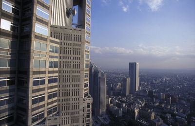 View of modern buildings against cloudy sky