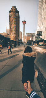 Portrait of man with umbrella on street against buildings in city