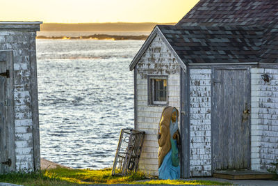 Woman standing by sea against building