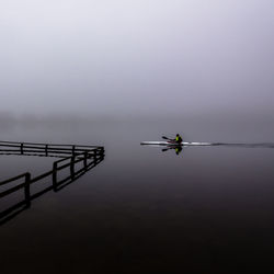 Kayaker on mirror-glass lake in silkeborg