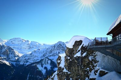 Observation point by snow covered mountains against clear blue sky