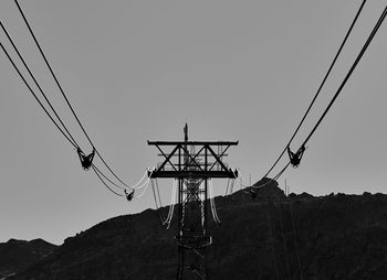 Low angle view of cable car pylon against sky