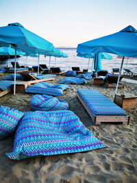 Chairs on beach against clear blue sky