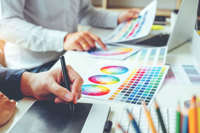 Design professional pointing at color swatch on table
