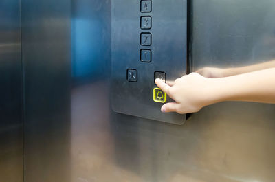 Cropped hand pressing button in elevator